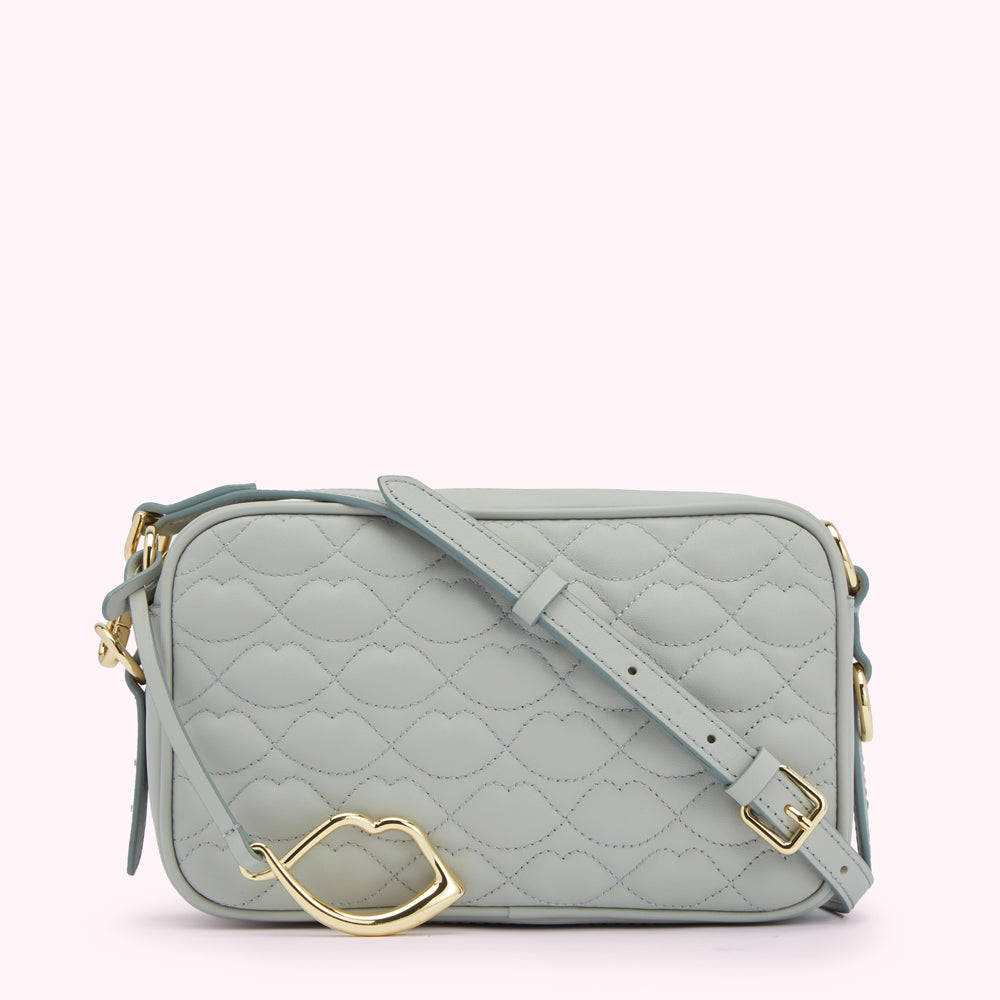 Light blue quilted crossbody bag with gold lip-shaped clasp.
