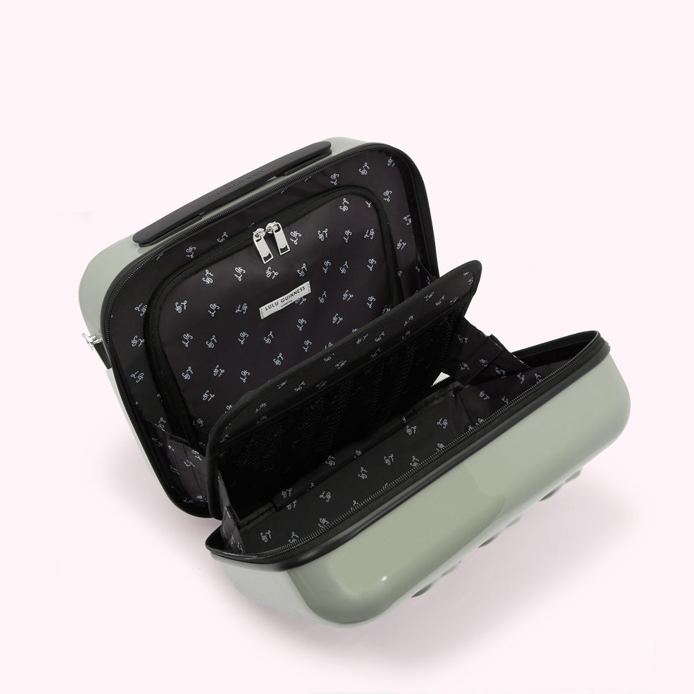 Open sage green Lulu Guinness suitcase with black interior lining and compartments.
