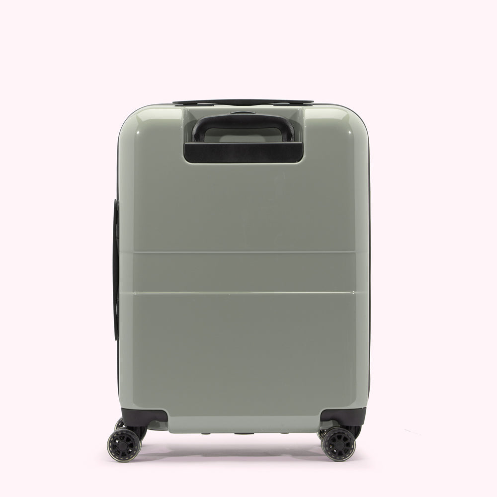 Sage green carry-on suitcase with black wheels and handle, shown from the back.
