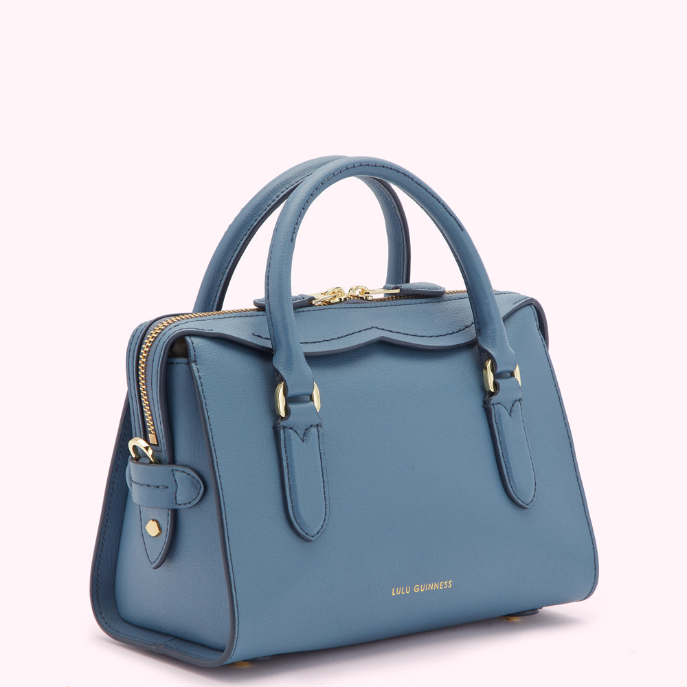 A powder blue Lulu Guinness satchel bag with gold hardware.
