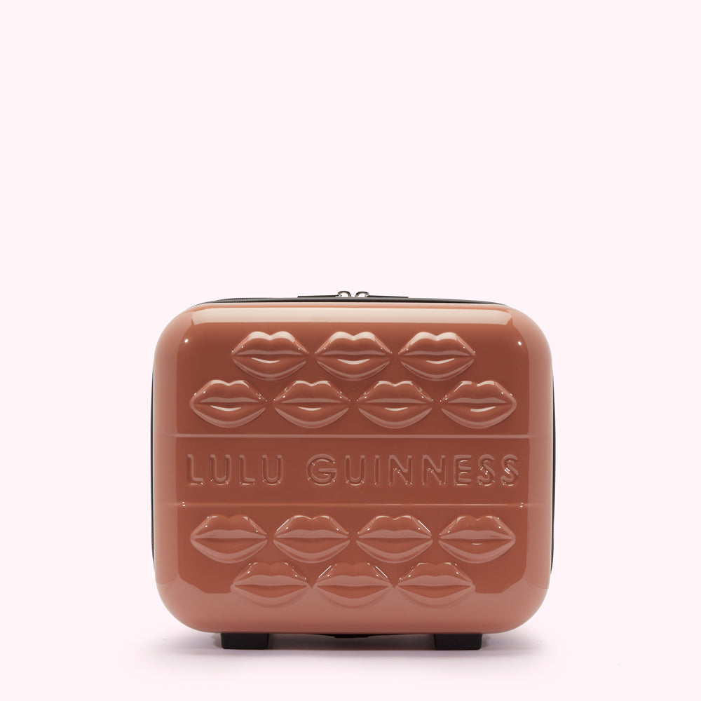 A dusty rose Lulu Guinness makeup case with embossed lips and the brand name.
