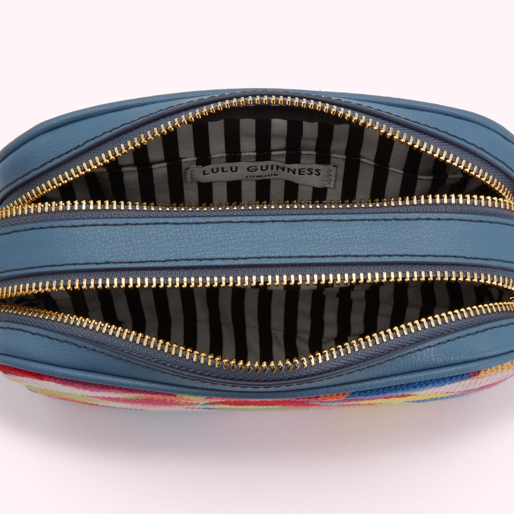 Inside of a Lulu Guinness London handbag with two compartments and a striped interior.