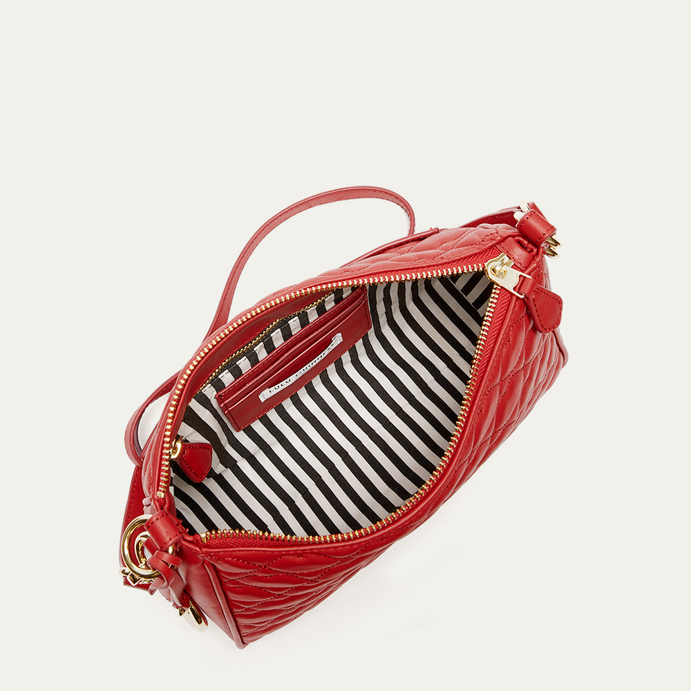 Red handbag with a striped interior on a light gray background