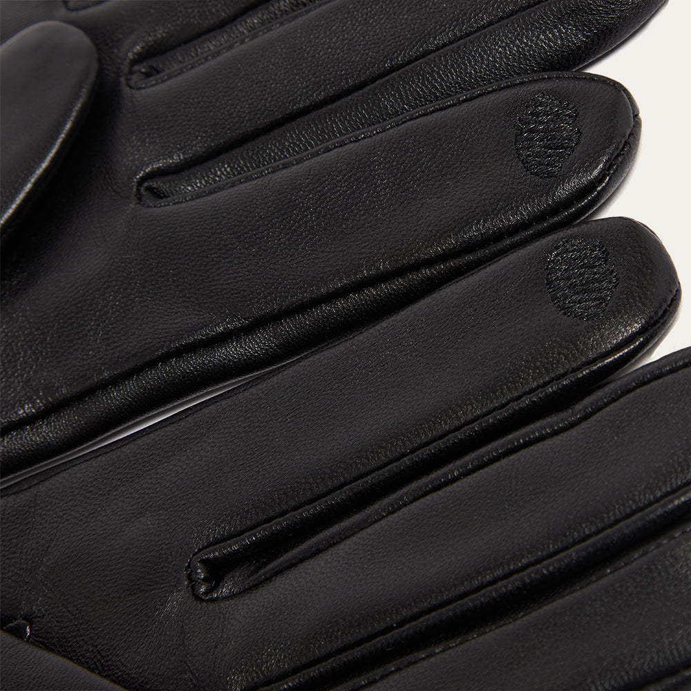 Close-up of black leather gloves with a brand logo on a white background