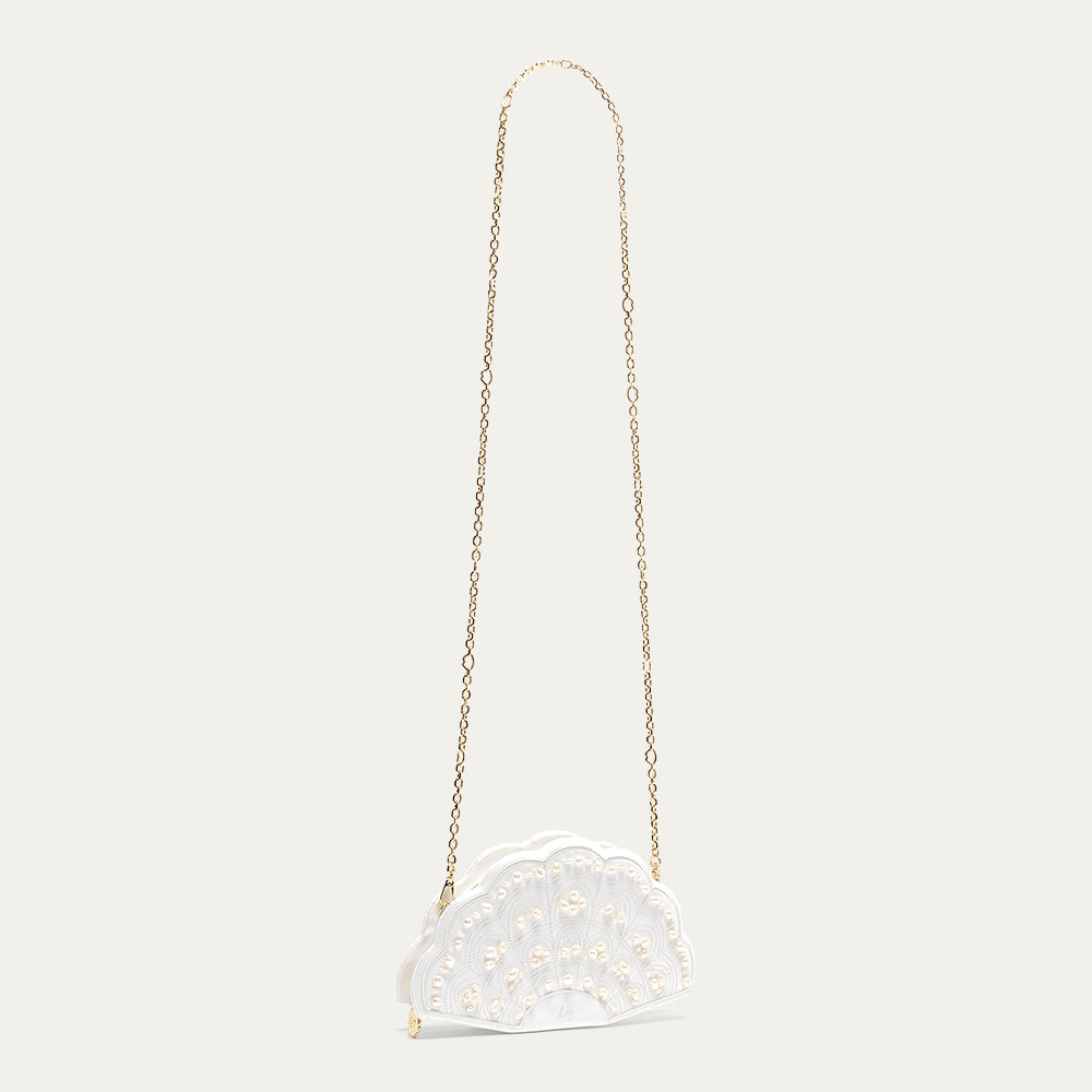 A white satin fan-shaped handbag with a gold chain on a light beige background