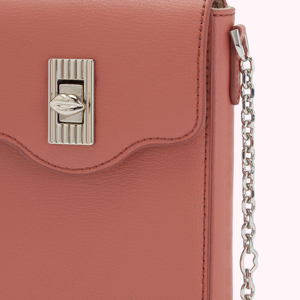 Close-up of a dusty rose-coloured leather handbag with a silver lip-shaped clasp and a silver chain strap.
