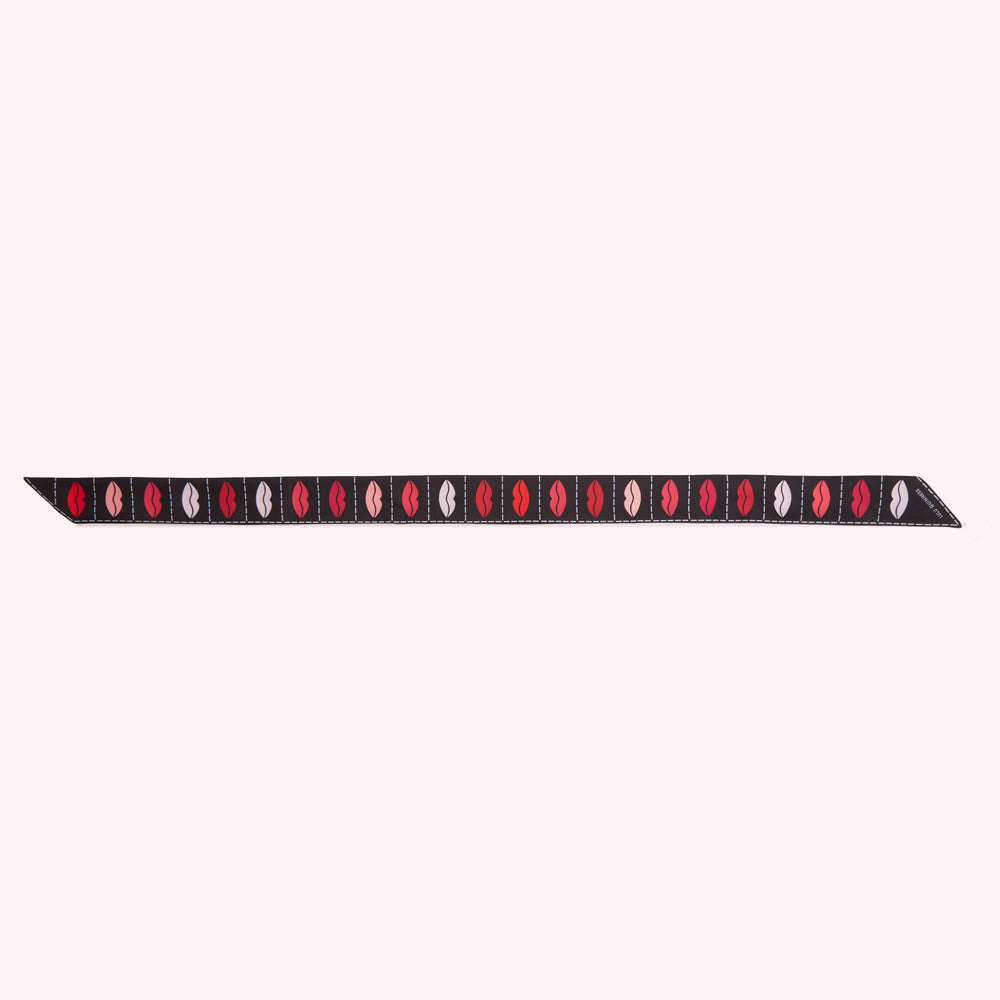 Black ribbon with a repeating pattern of multi-coloured lips.

