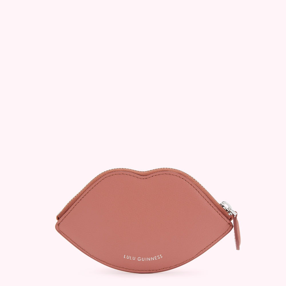 Dusty rose pink lip-shaped zippered coin purse by Lulu Guinness, against a white background.
