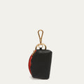 A small black pebbled leather pouch with a gold-tone lobster clasp and ring, featuring a red interior lining visible on the side, set against a light off-white background.