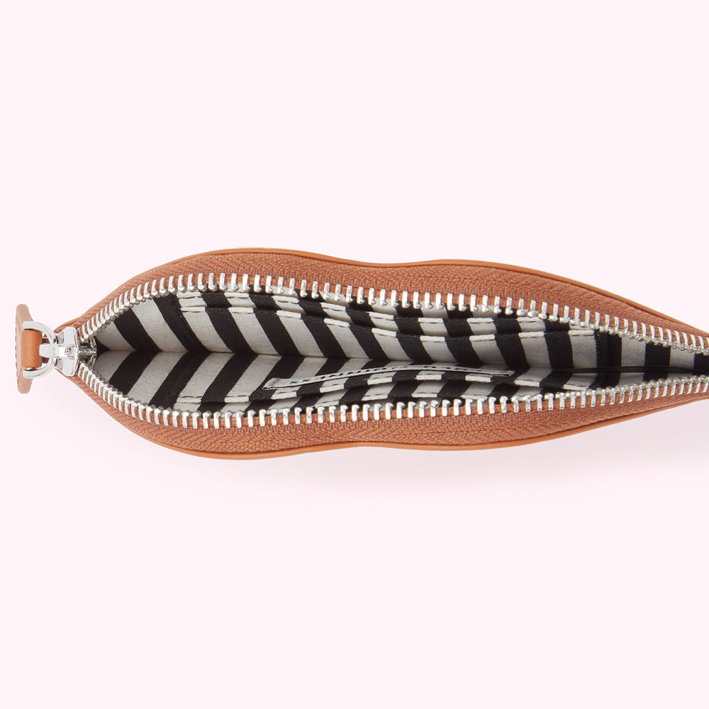Tan leather pouch open to reveal a black and white striped interior.
