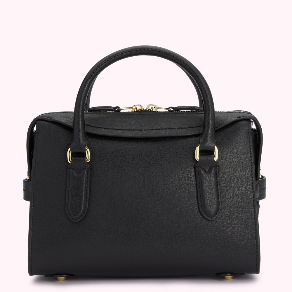 Black leather handbag with gold hardware, viewed from the back.
