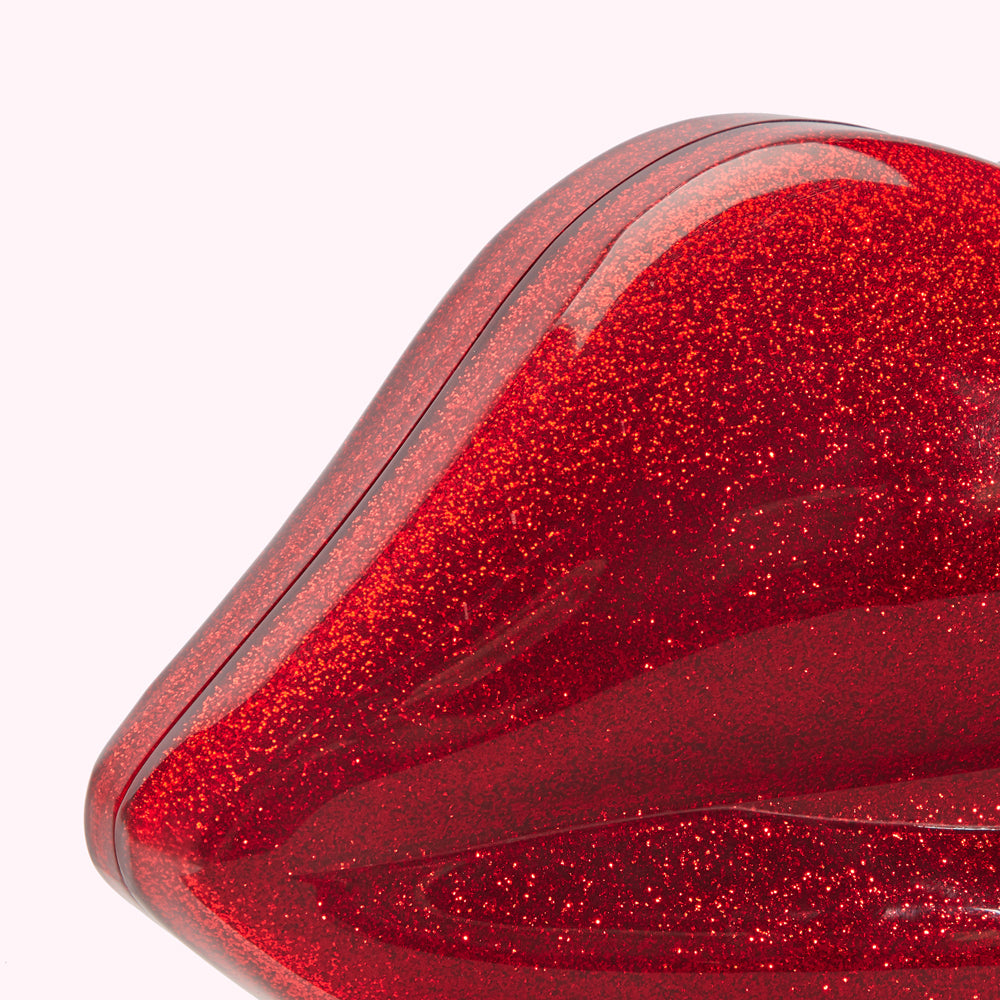 Close-up of a red glitter handbag shaped like a lip.
