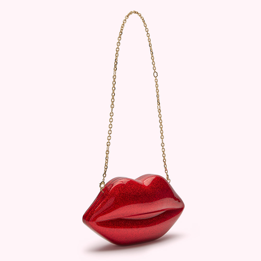 Red glitter lip-shaped clutch with gold chain strap.

