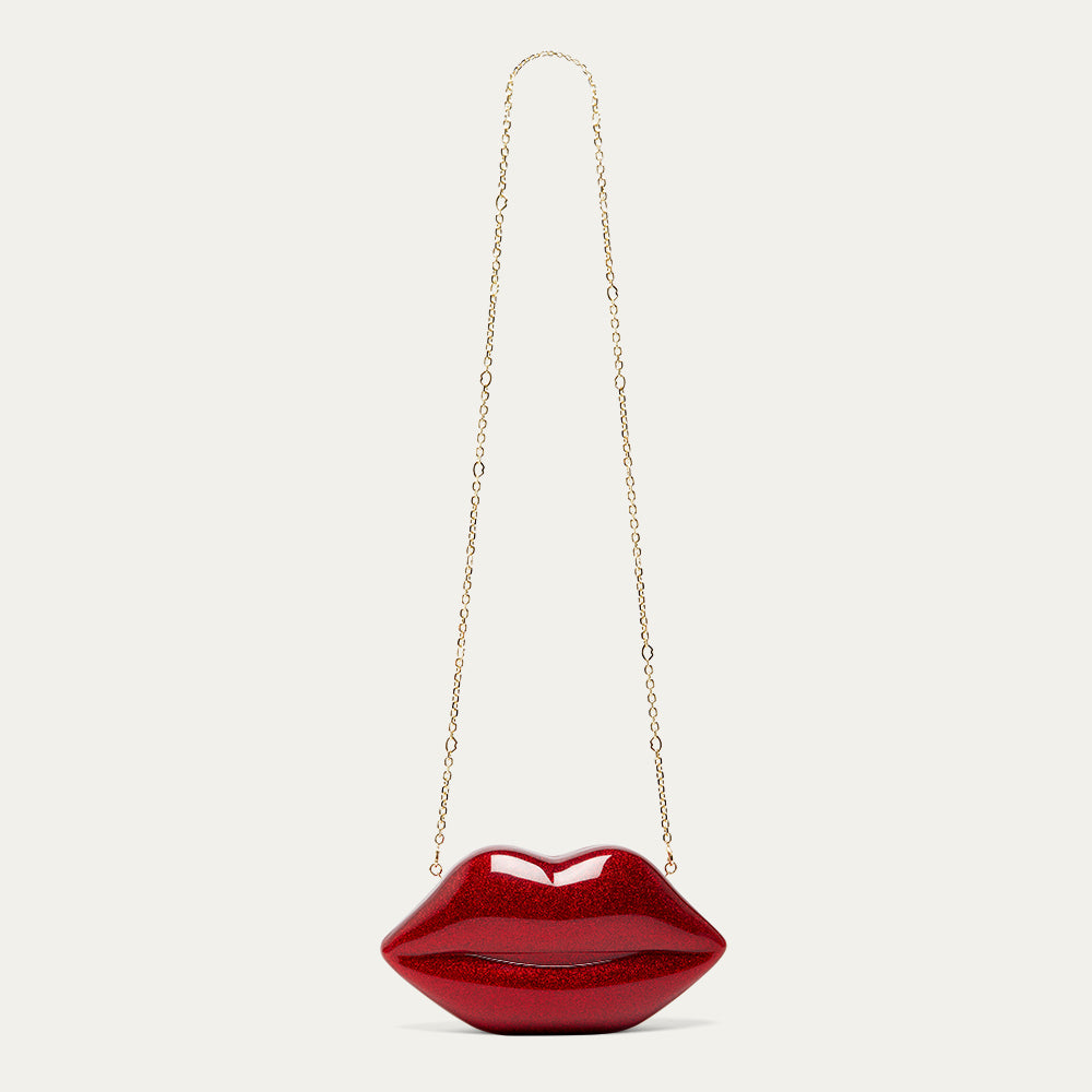 Red lip-shaped handbag with a gold chain on a light grey background