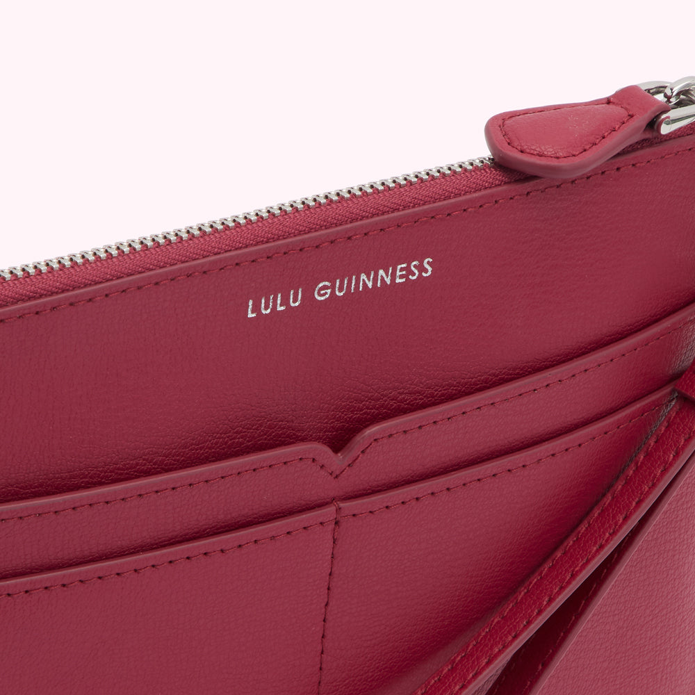 Close-up of a red Lulu Guinness zip-around wallet.