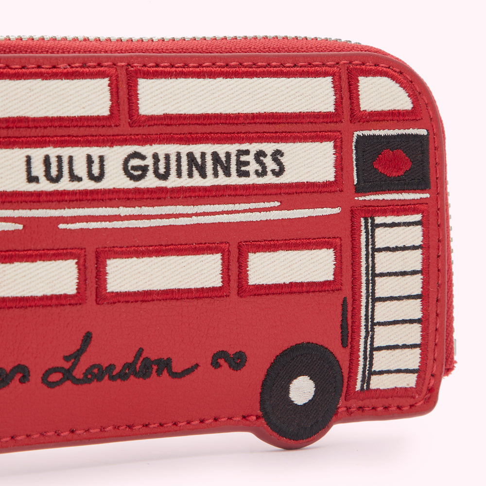 Red Lulu Guinness zip-around wallet featuring an embroidered London bus design.