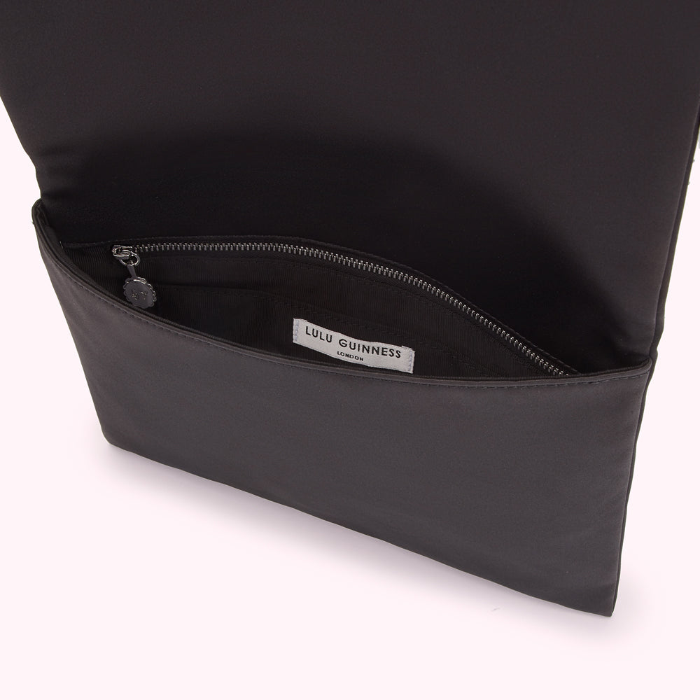 Black Lulu Guinness London clutch opened to reveal interior and zipper.