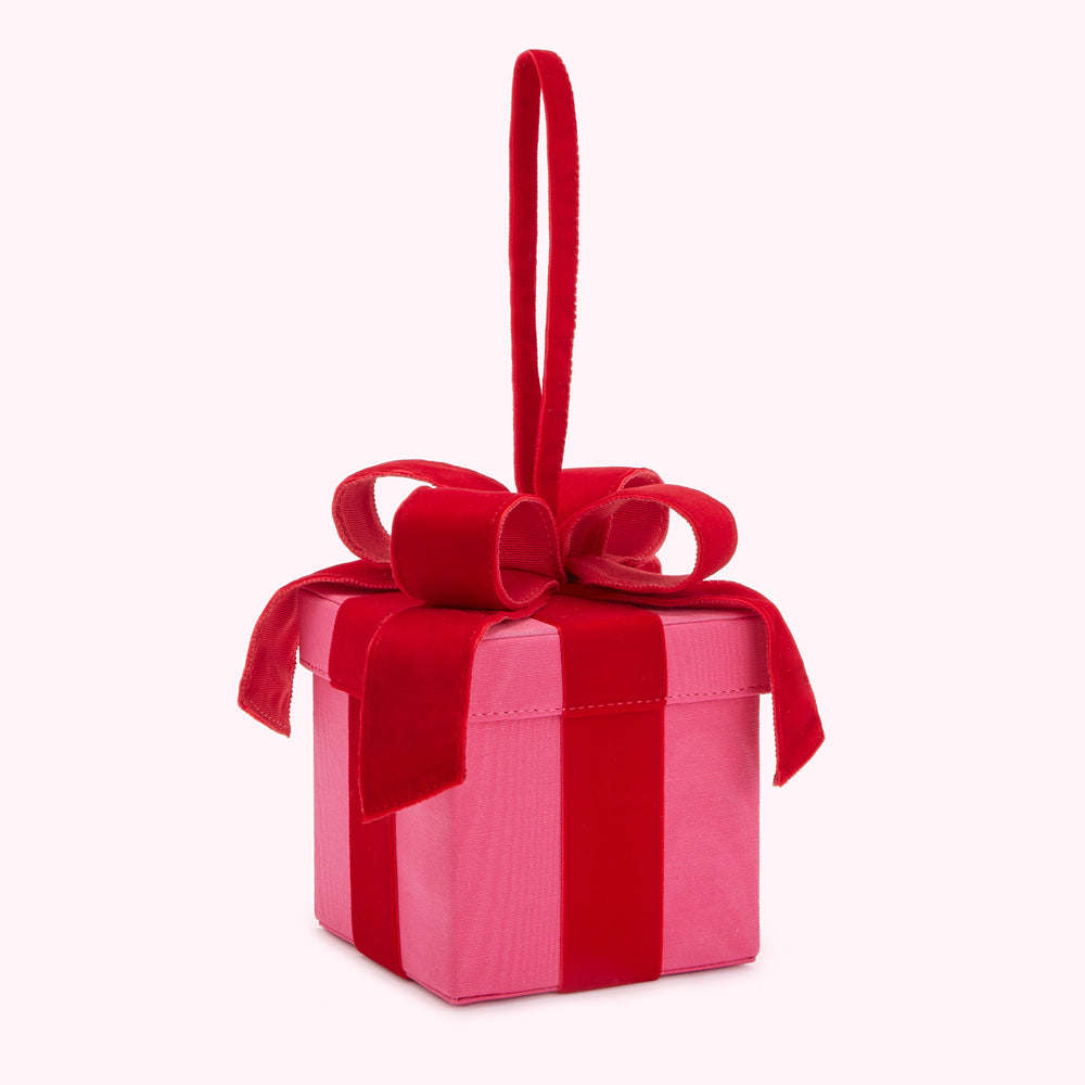 Pink velvet gift box with a large red velvet bow and ribbon.
