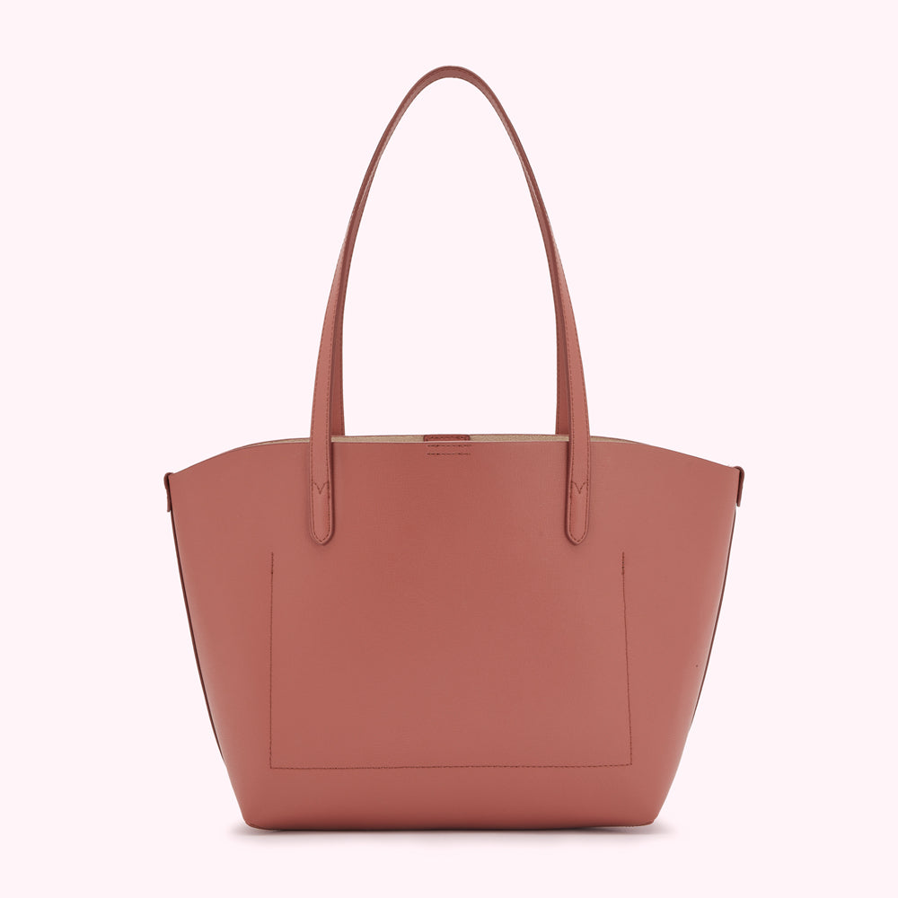 Dusty rose leather tote bag with tan interior.
