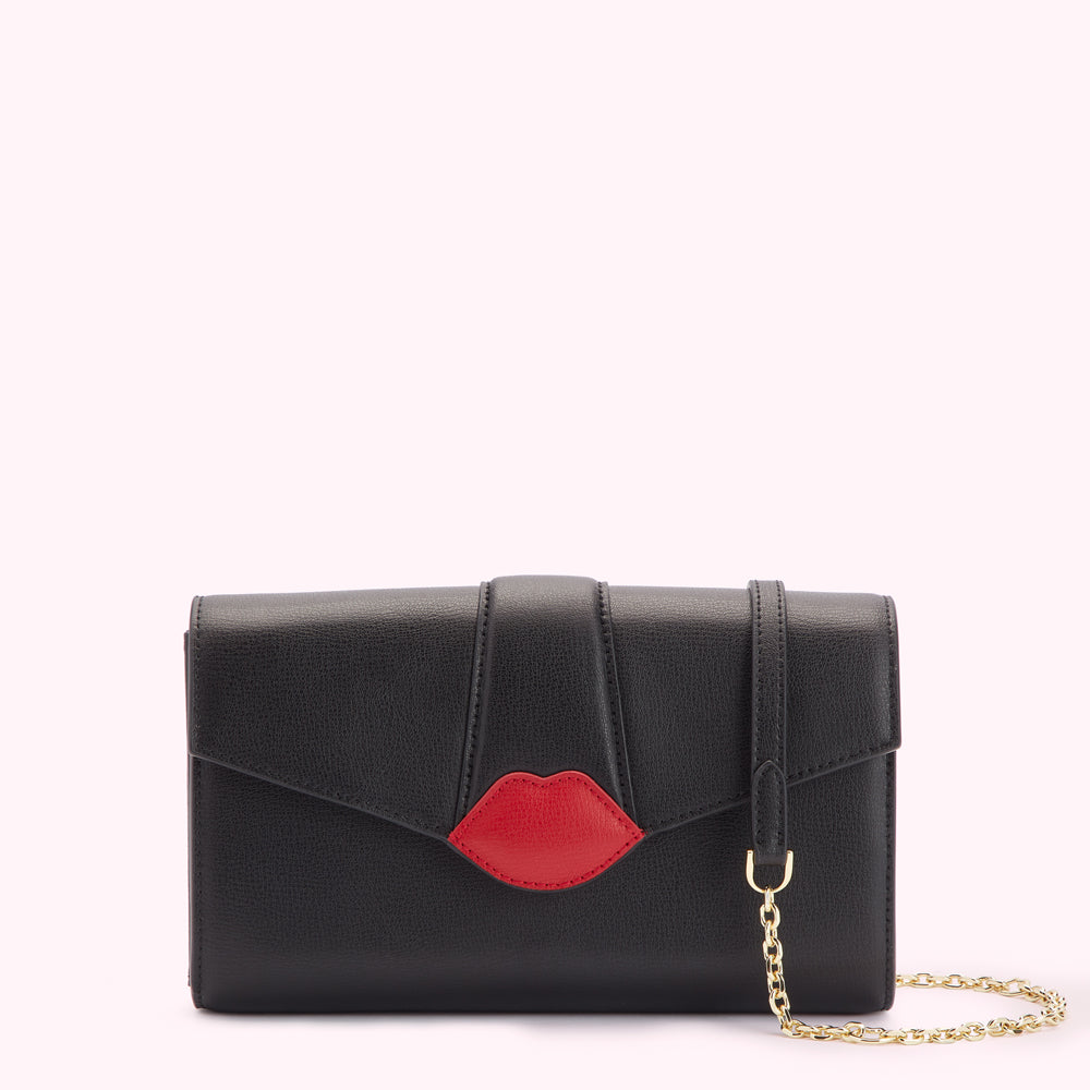 Black leather clutch with a red lip detail and gold chain strap.
