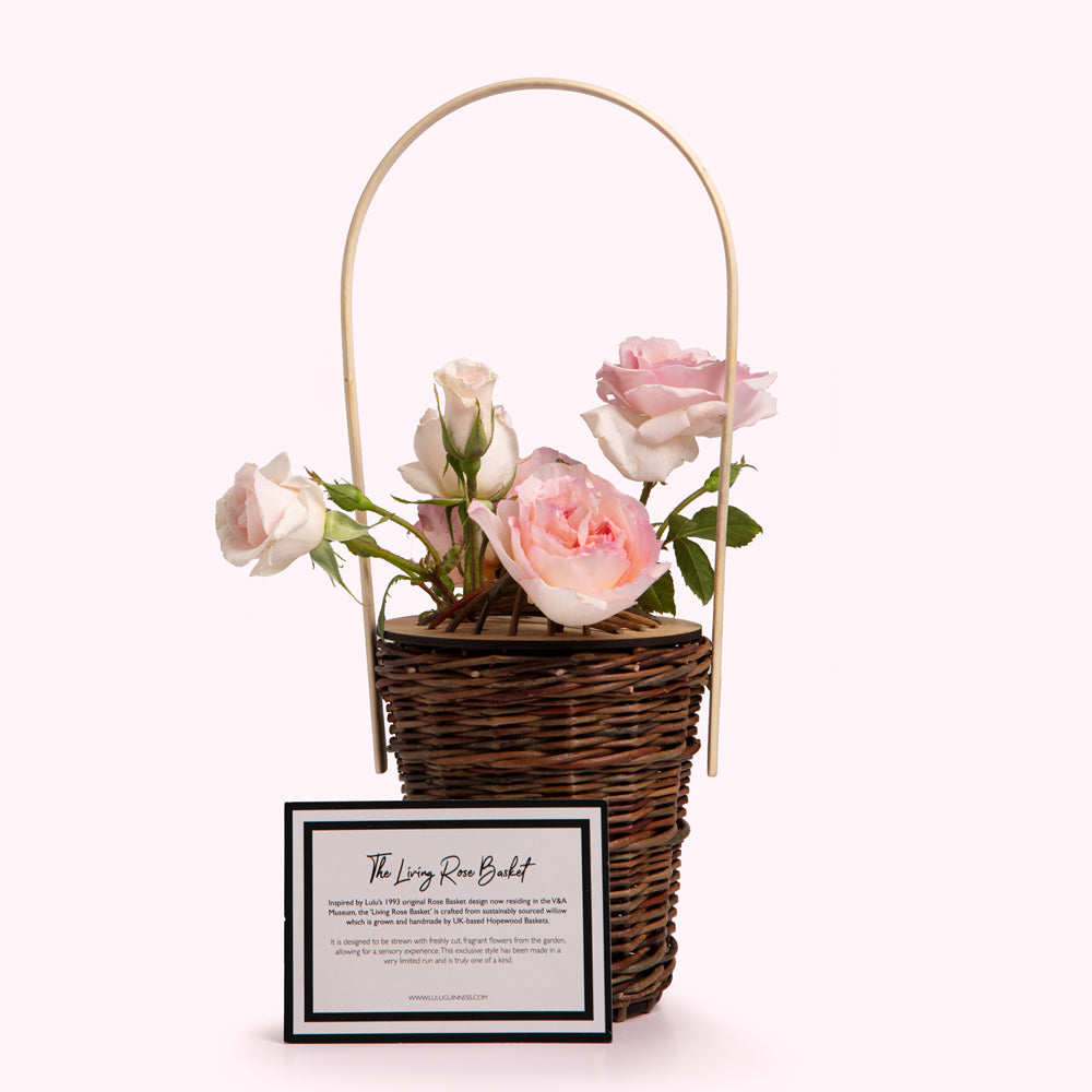 Pink roses in a woven basket with a handle; information card visible below.
