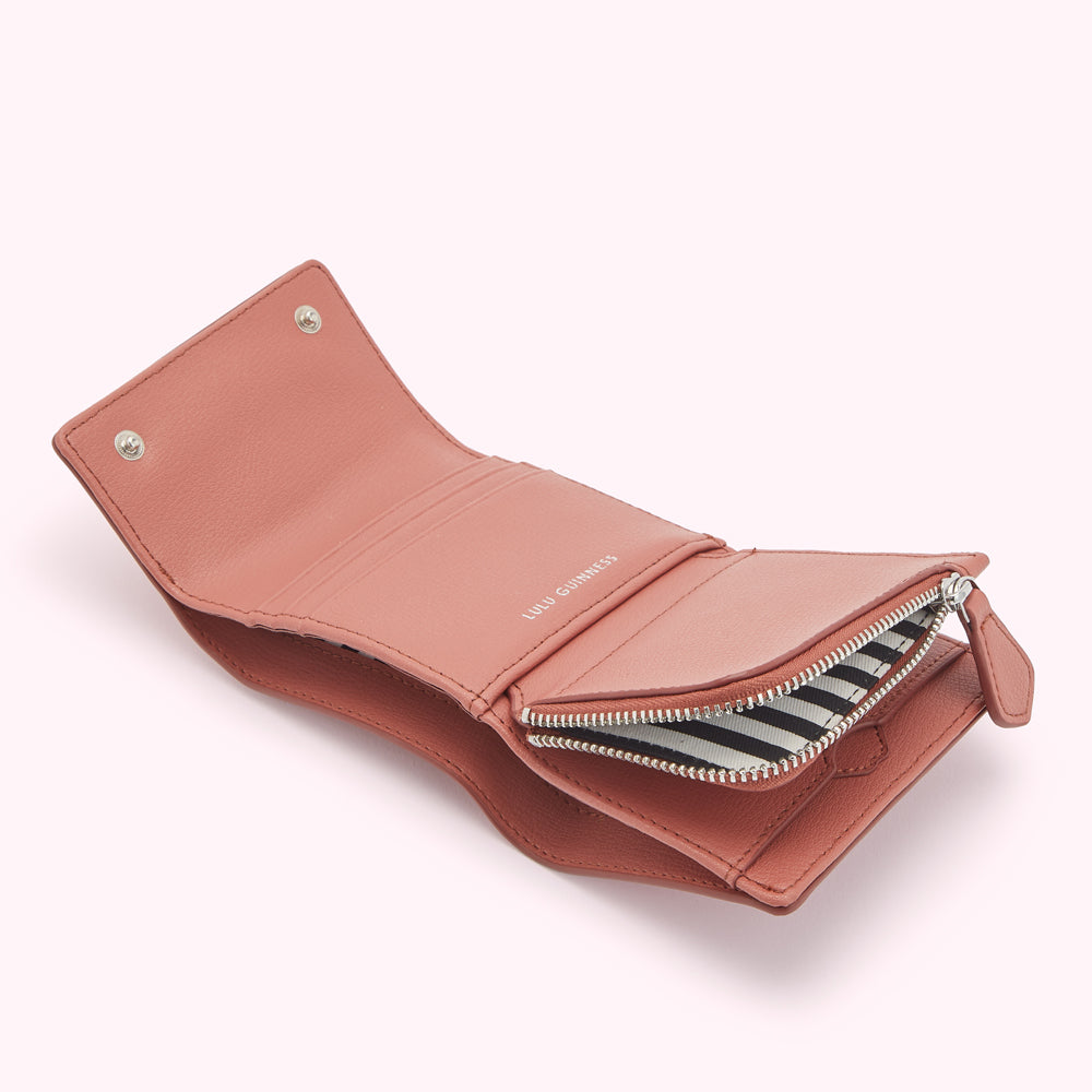 Dusty pink Lulu Guinness zip-around wallet open to reveal interior.
