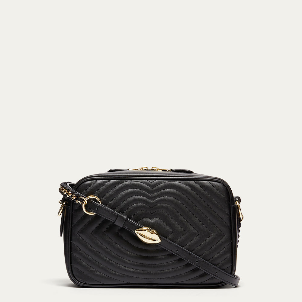 Black quilted handbag with gold accents on a light gray background