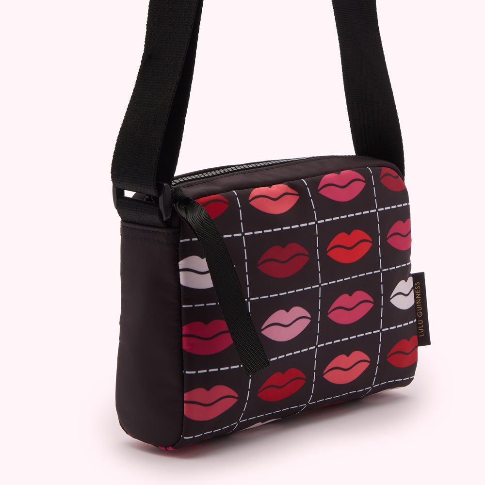 Black crossbody bag with a lips print.