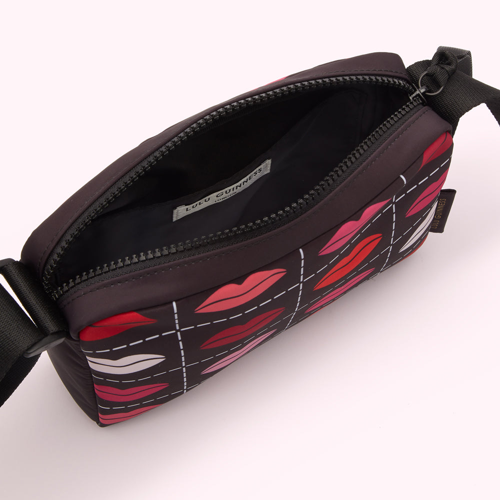 Open black crossbody bag with a red and pink lips pattern.
