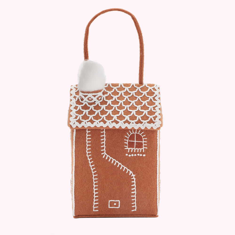 Brown felt gingerbread house-shaped gift bag with white felt detailing and a fluffy white felt chimney.
