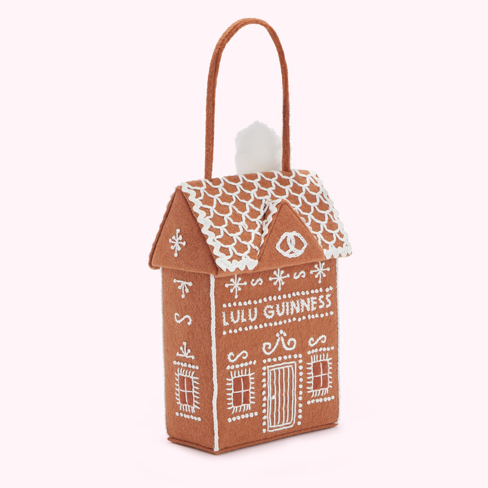 Brown felt gingerbread house-shaped handbag with white embroidered details and the text "Lulu Guinness".