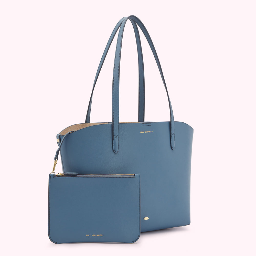 A teal Lulu Guinness tote bag and matching pouch set against a white background.
