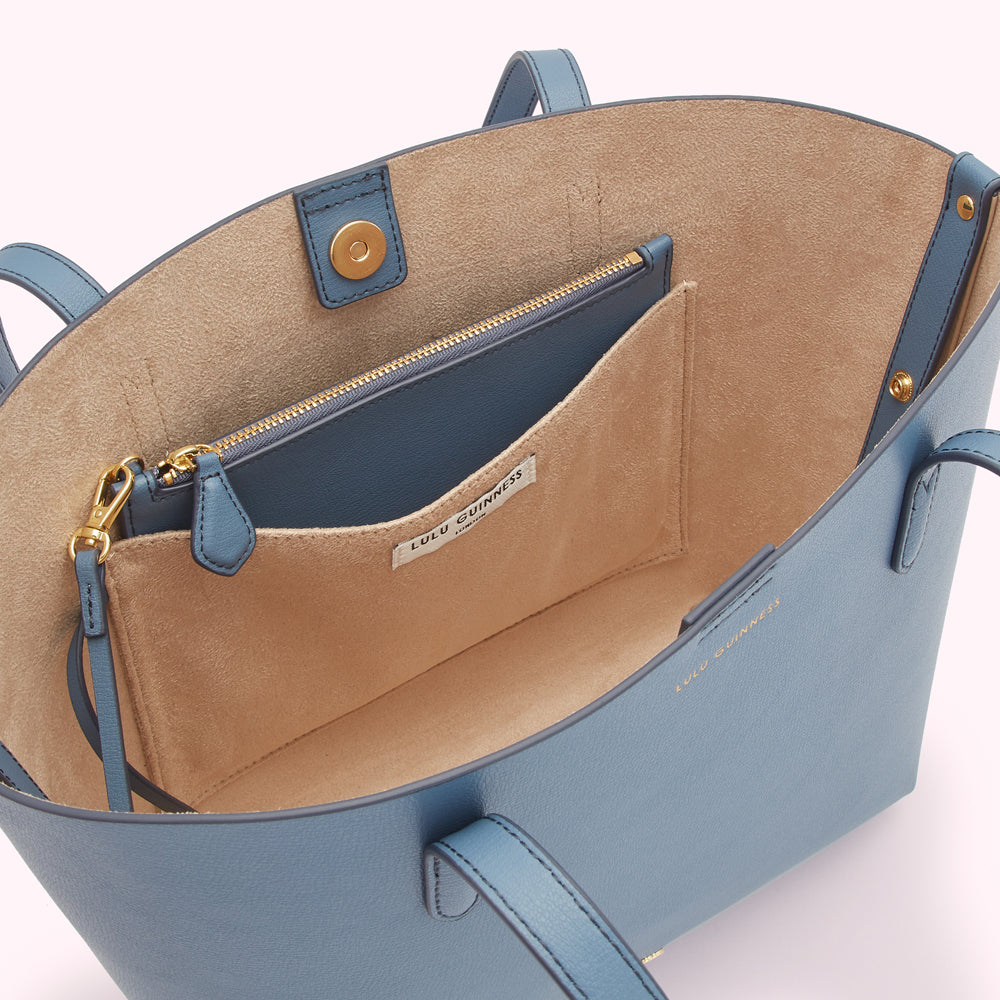 Inside view of a blue Lulu Guinness tote bag showing beige lining and an internal zipped pocket.