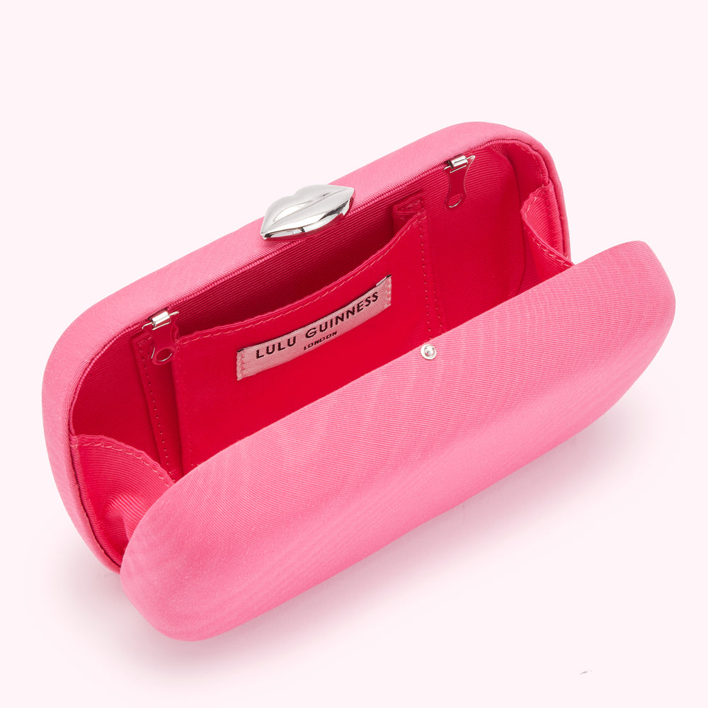Pink Lulu Guinness clutch open to reveal interior and silver lip clasp.
