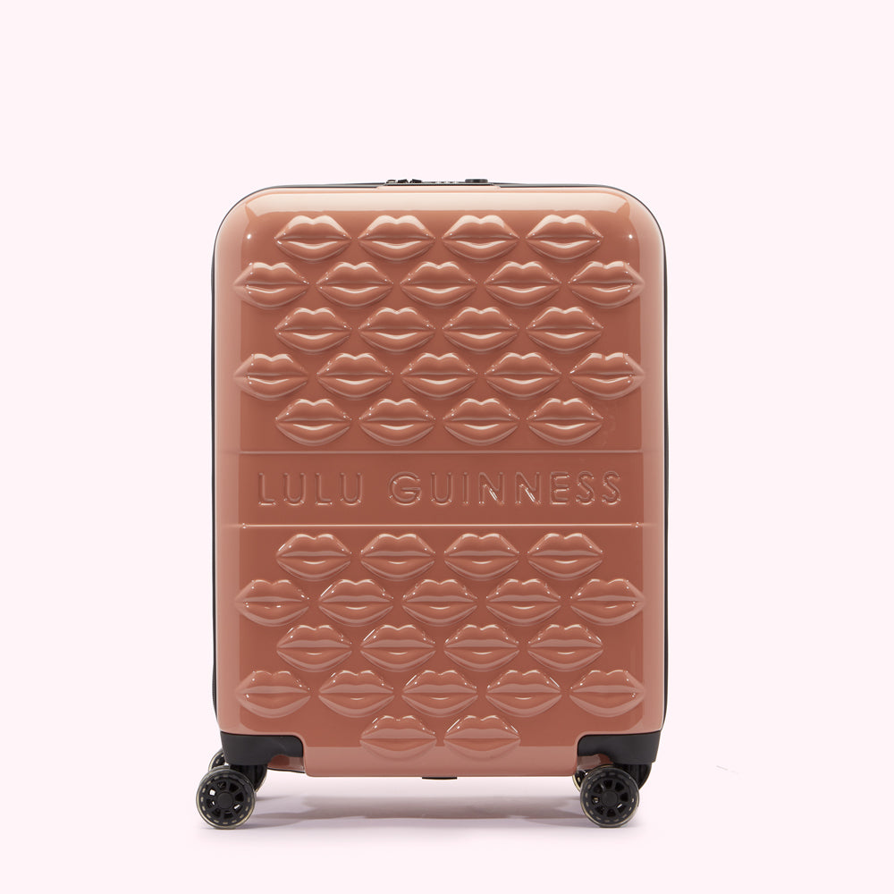 A mauve Lulu Guinness suitcase covered in a repeating pattern of embossed lips.