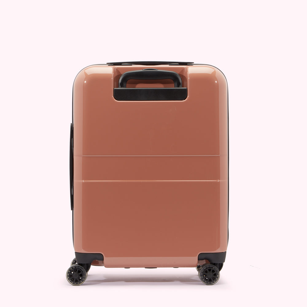 A dusty rose-coloured carry-on suitcase on a white background.