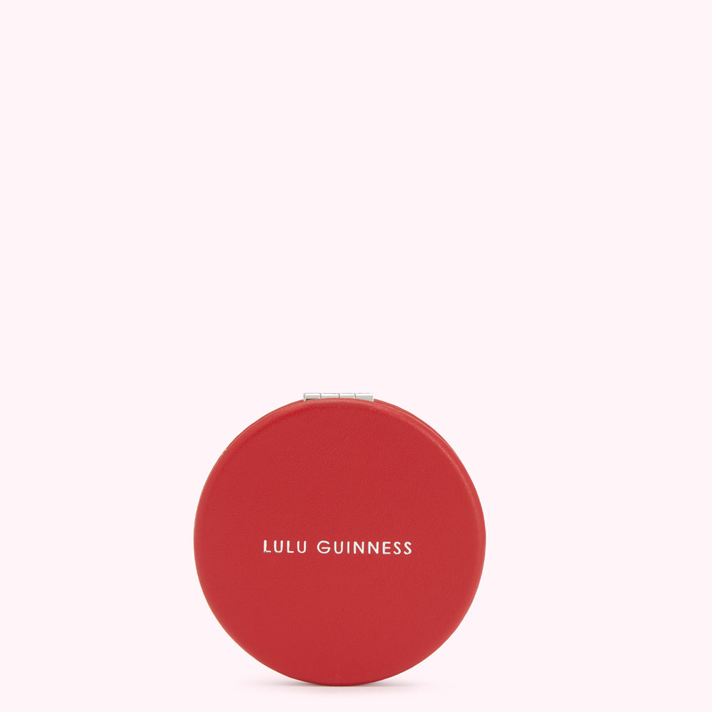Red circular compact mirror by Lulu Guinness.
