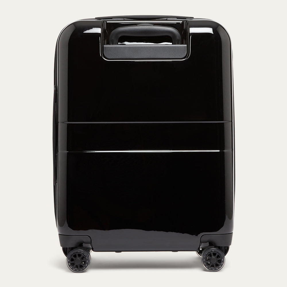 Black suitcase with wheels on a light gray background
