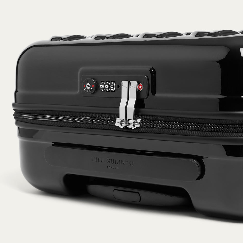 Black suitcase with visible brand logo on a white background
