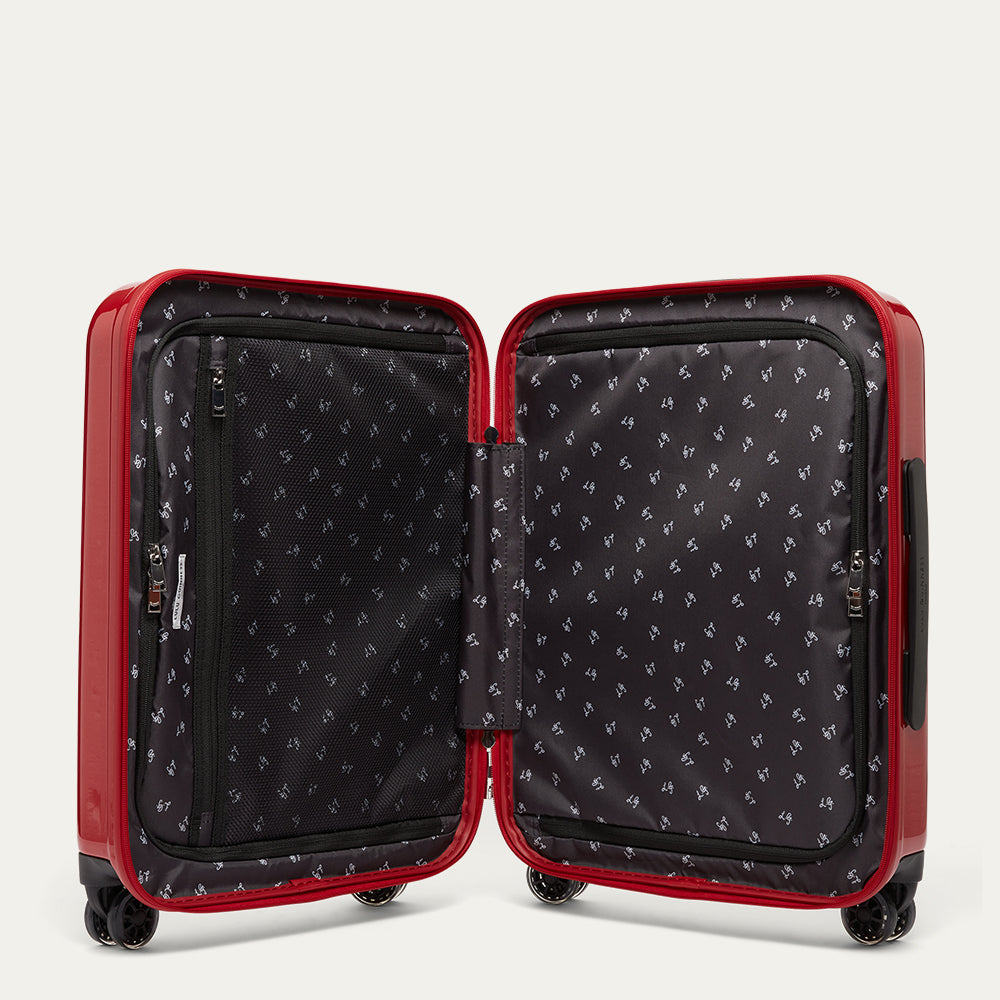 Open red suitcase with black interior on a light gray background