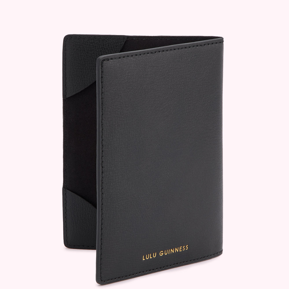 Black Lulu Guinness passport holder with gold logo.
