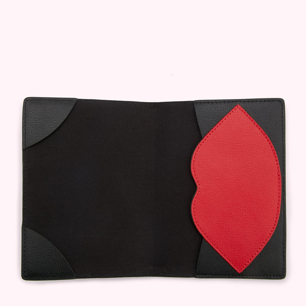 Black passport holder with a red lip-shaped detail.
