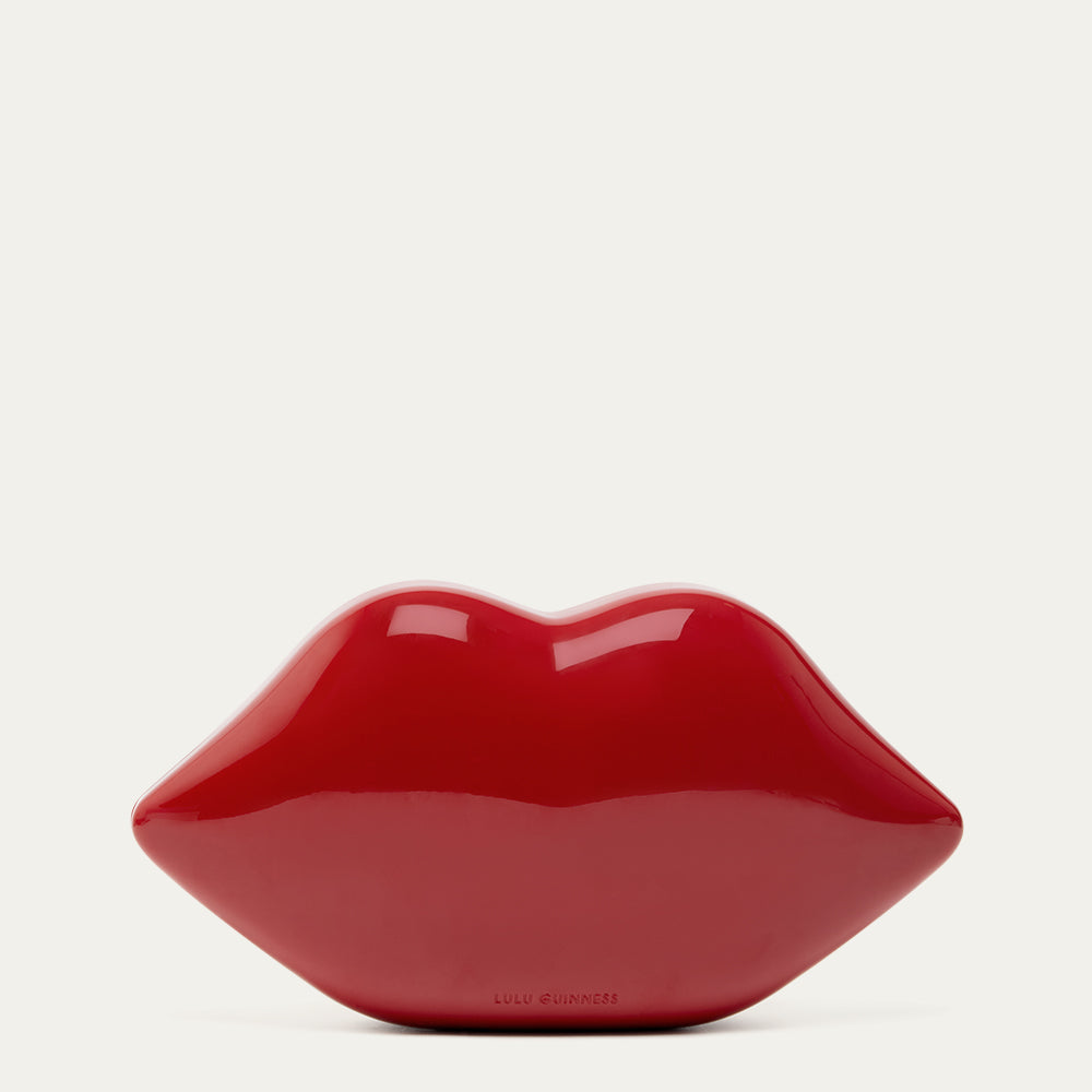 Red lip-shaped clutch on a light grey background