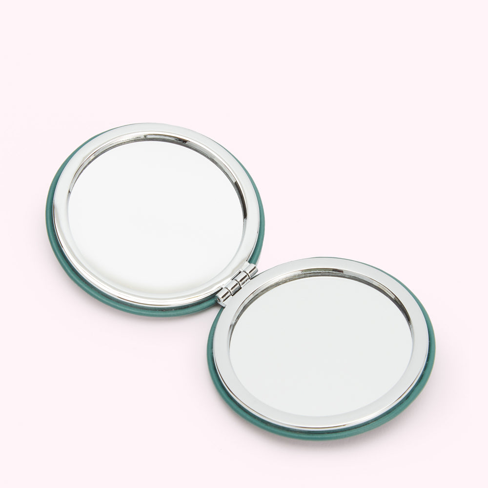 Open teal compact mirror with two reflecting surfaces.
