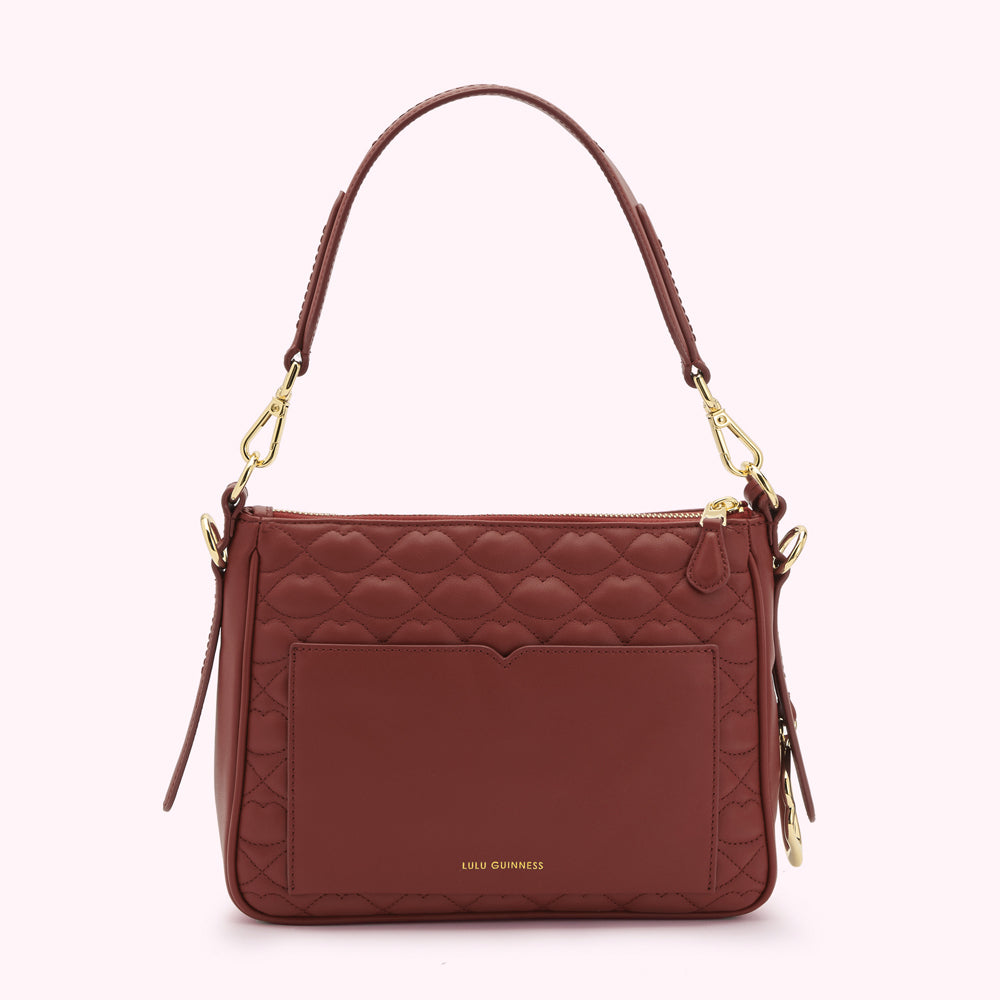 Russet quilted Lulu Guinness shoulder bag with gold hardware, featuring a front pocket and lip print design.
