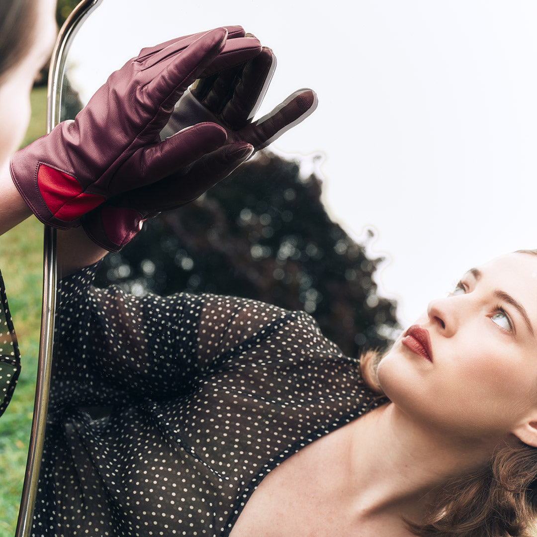 Person wearing a glove in front of a mirror