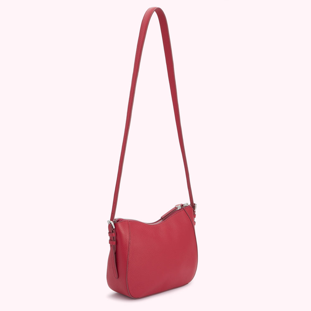 Red leather crossbody bag with a long strap.
