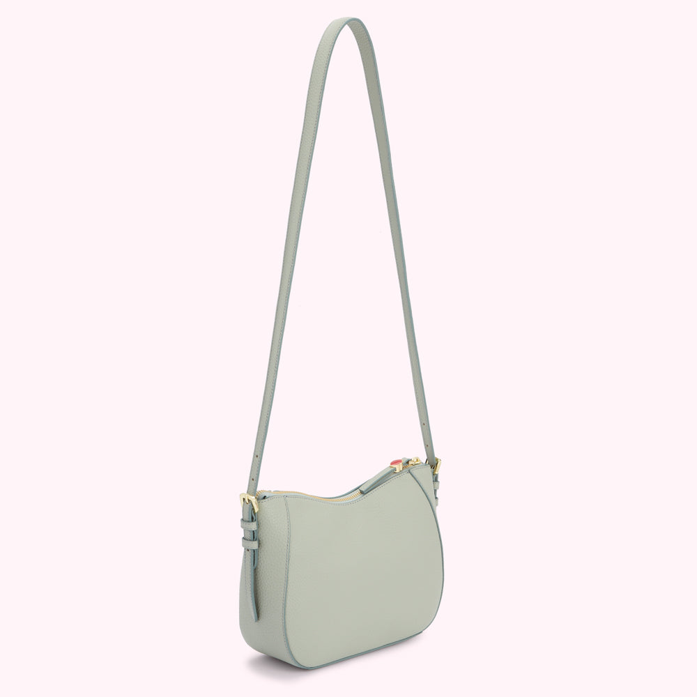 Light blue leather crossbody bag on white background.
