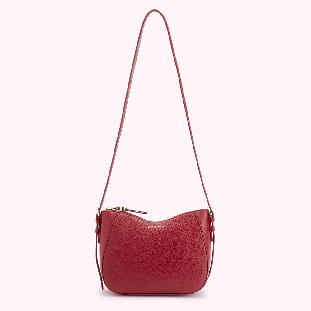 Red leather crossbody bag with gold zipper and logo.