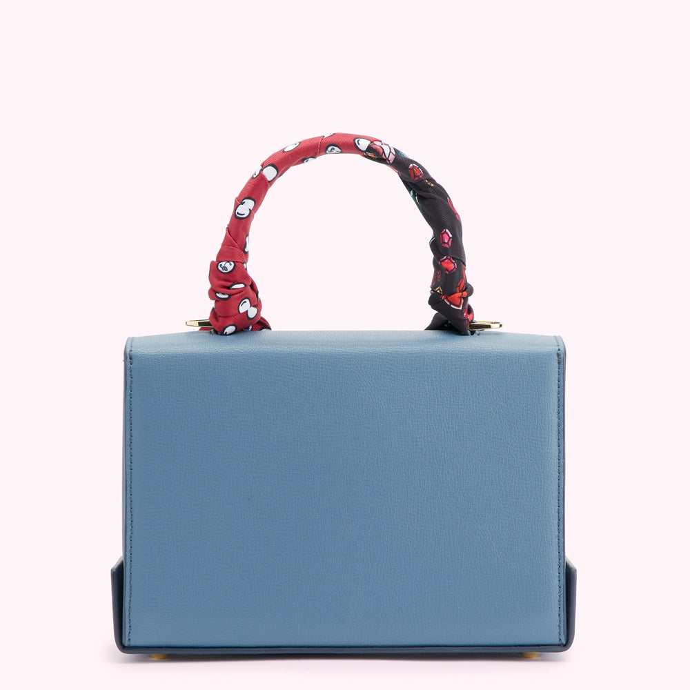 Dusty blue structured handbag with a patterned scarf handle.
